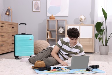 Travel blogger using laptop for planning trip at home