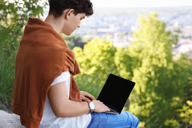 Handsome travel blogger using modern laptop outdoors