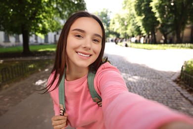 Beautiful young travel blogger takIng selfie outdoors