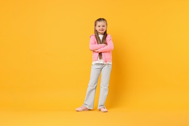 Photo of Cute little dancer posing on yellow background, space for text