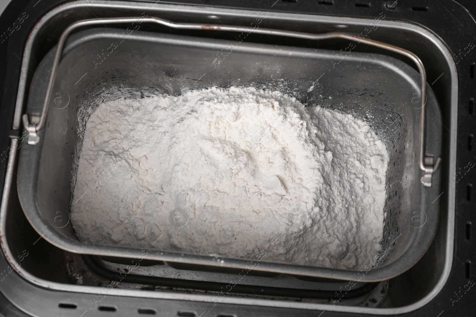 Photo of Modern bread maker with flour, closeup view