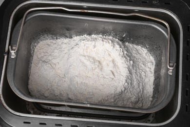 Photo of Modern bread maker with flour, closeup view