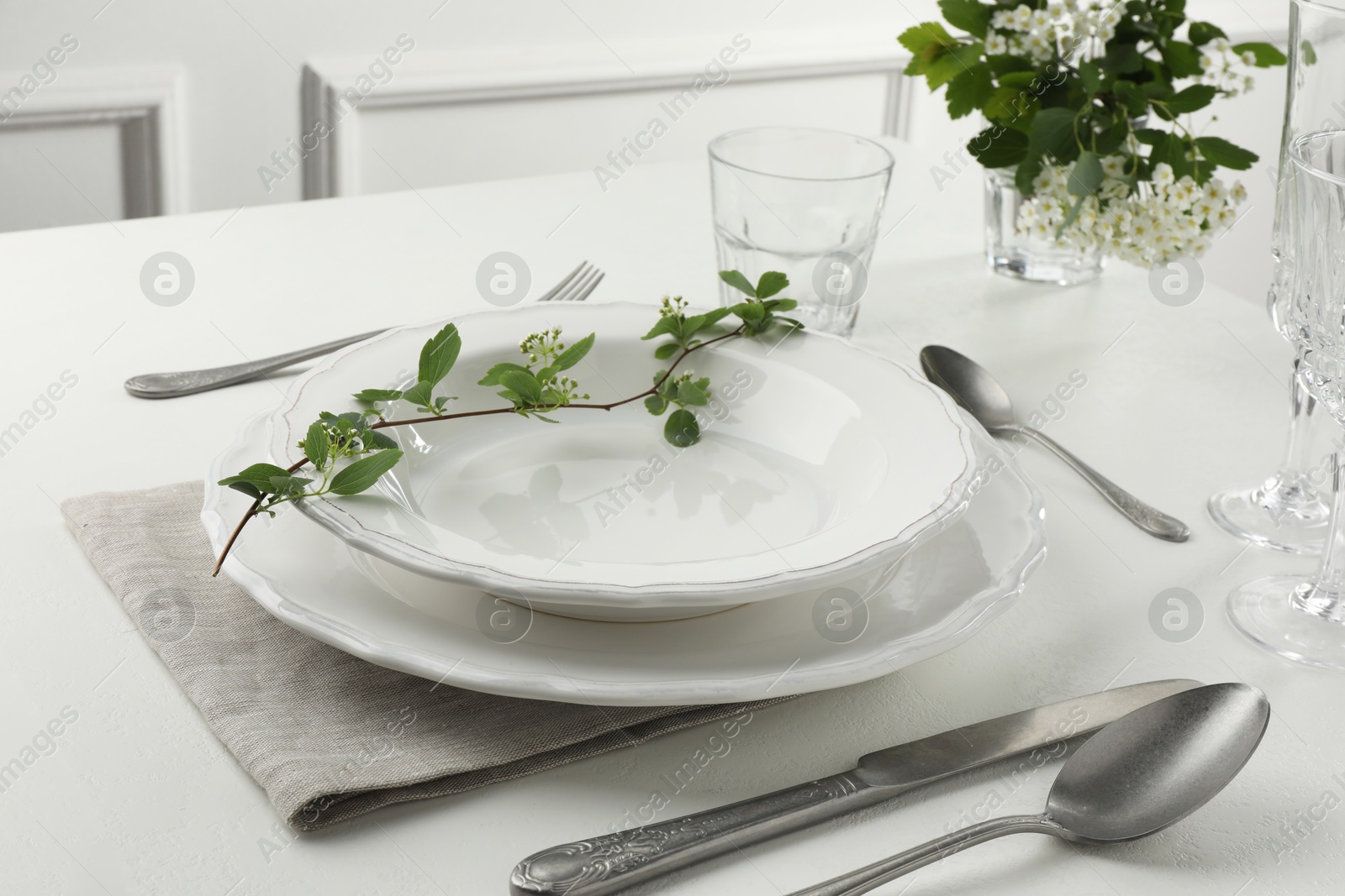 Photo of Stylish setting with cutlery and plates on white textured table