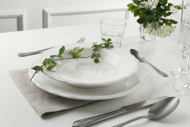 Stylish setting with cutlery and plates on white textured table