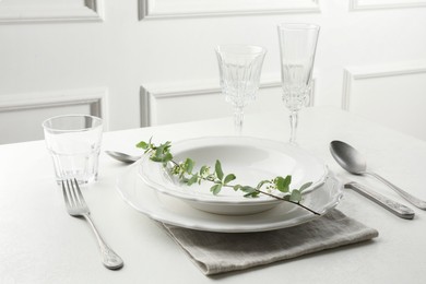 Photo of Stylish setting with cutlery and plates on white textured table