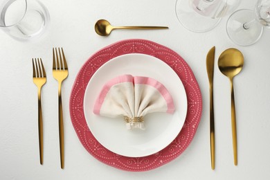 Photo of Stylish setting with cutlery, napkin and plates on white textured table, flat lay