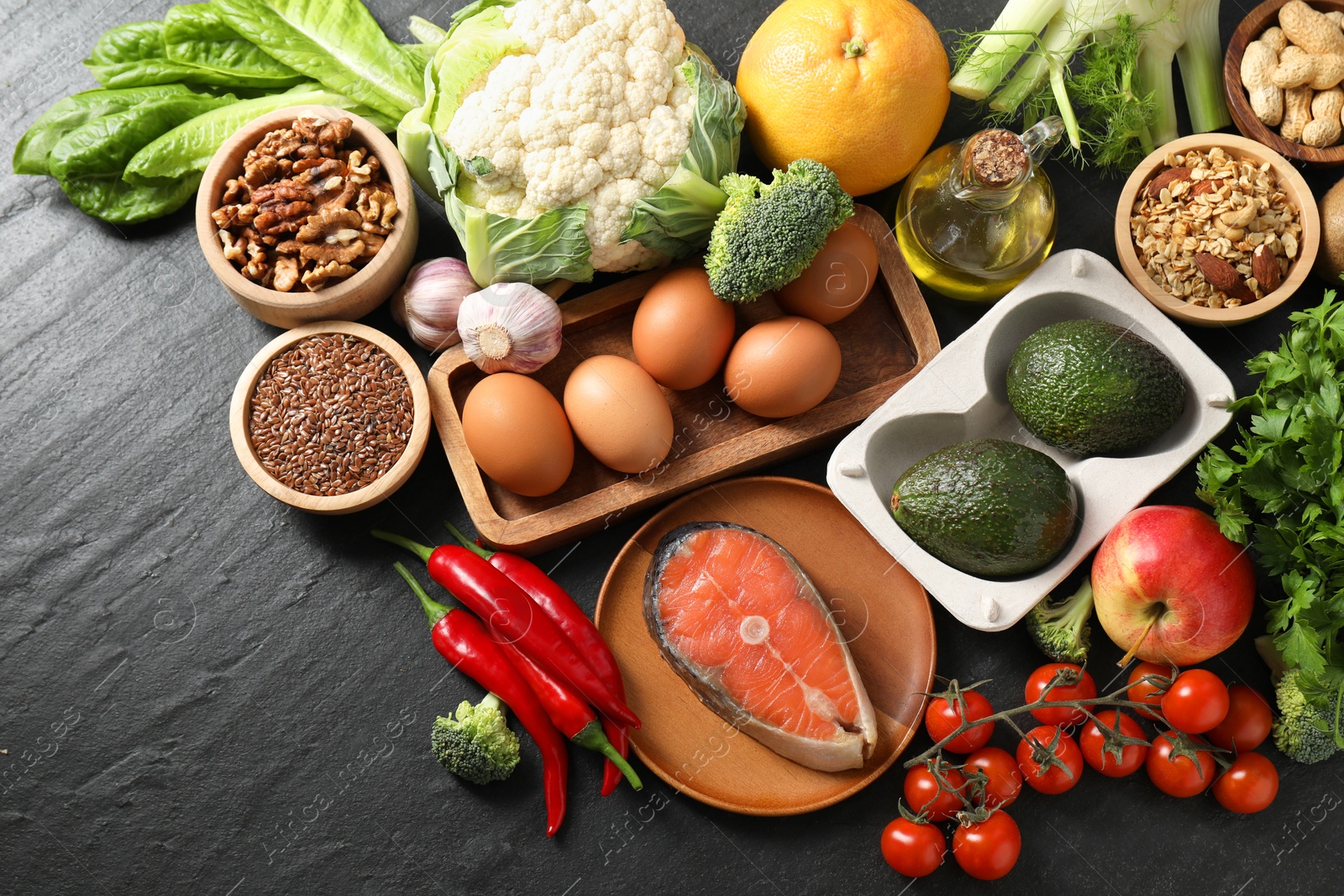 Photo of Many different healthy food on dark textured table, flat lay