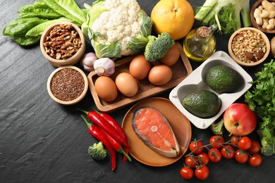 Many different healthy food on dark textured table, flat lay