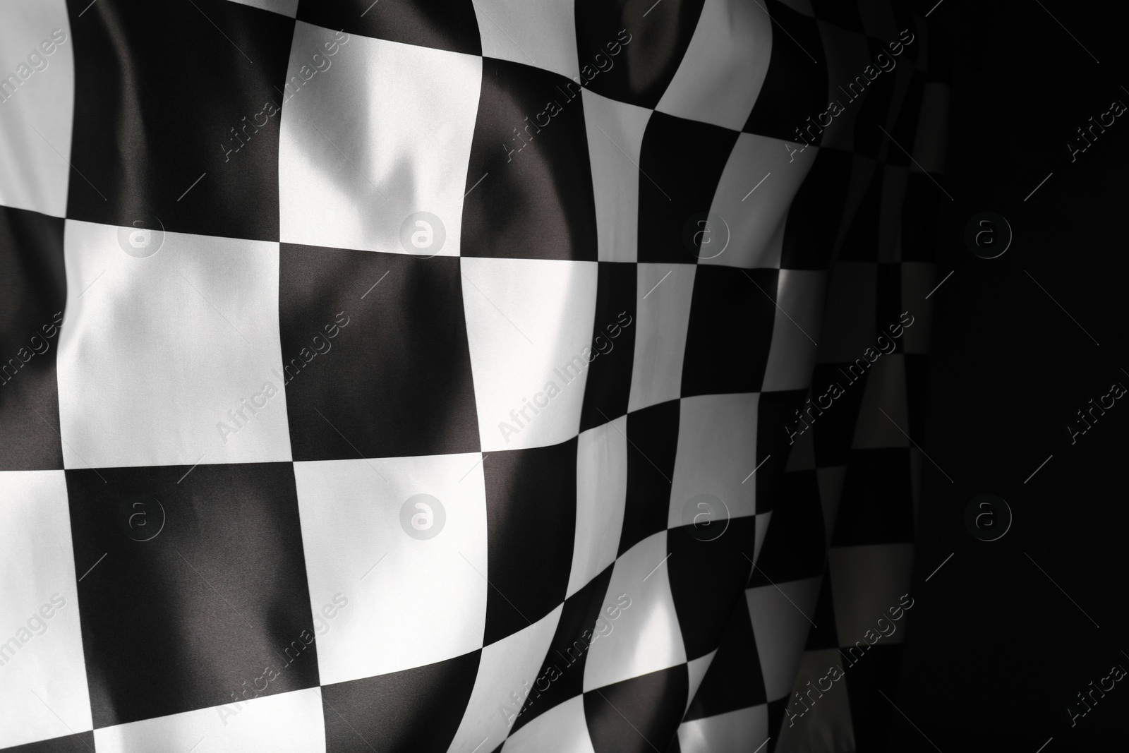 Photo of Checkered flag on black background, closeup view