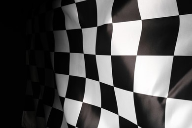 Checkered flag on black background, closeup view
