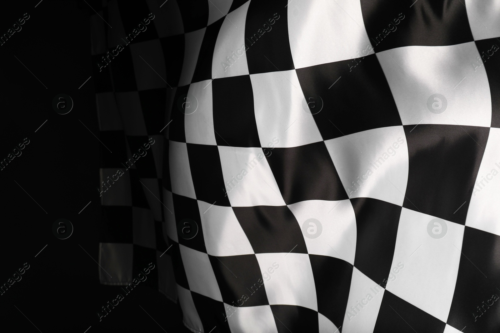 Photo of Checkered flag on black background, space for text