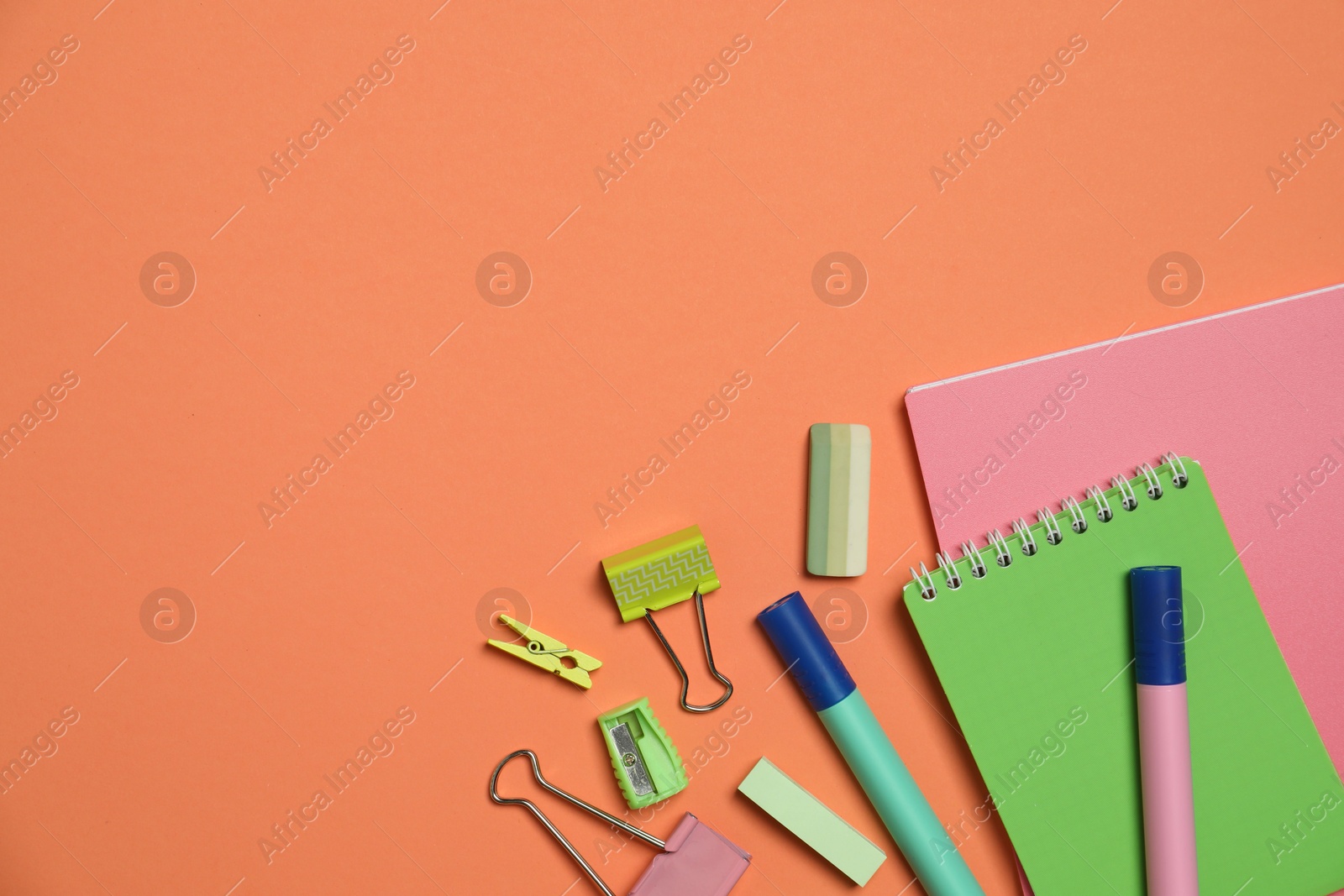 Photo of Flat lay composition with notebooks and different stationery on orange background, space for text