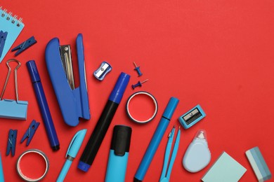 Photo of Flat lay composition with stapler and different stationery on red background, space for text