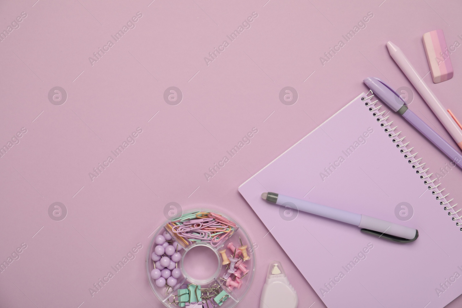 Photo of Flat lay composition with notebook and different stationery on violet background, space for text