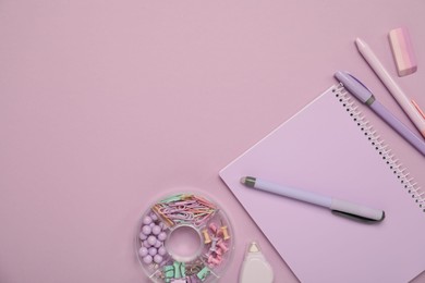 Flat lay composition with notebook and different stationery on violet background, space for text