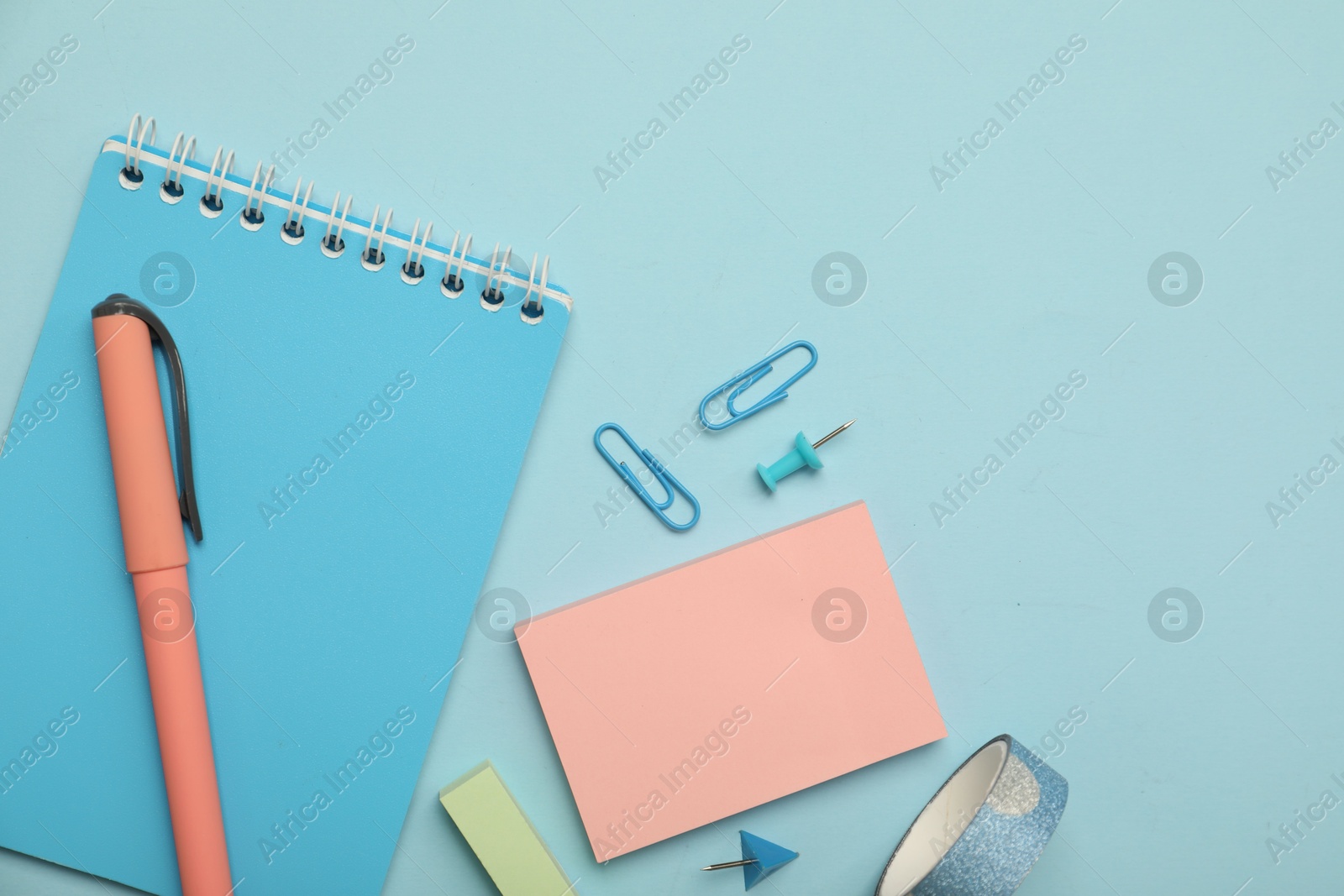 Photo of Flat lay composition with notebook and different stationery on light blue background, space for text