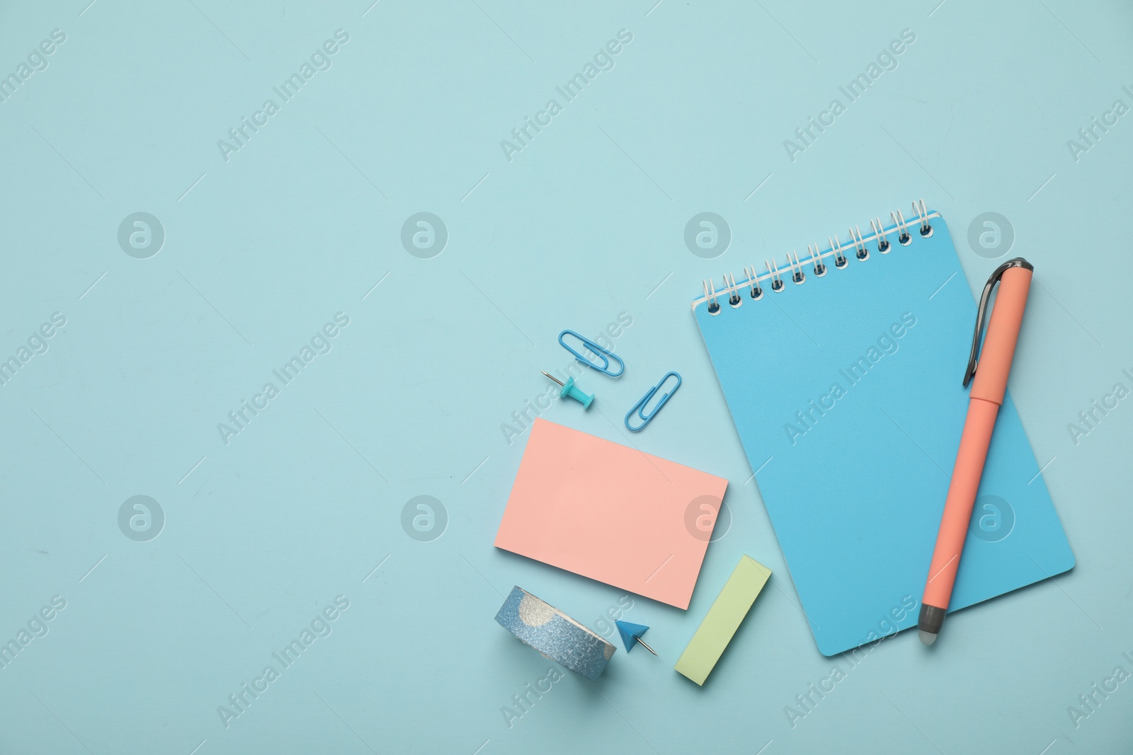 Photo of Flat lay composition with notebook and different stationery on light blue background, space for text