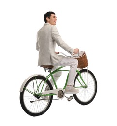 Photo of Smiling man riding bicycle with basket on white background