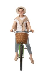 Smiling woman riding bicycle with basket against white background