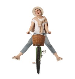 Smiling woman having fun while riding bicycle with basket on white background