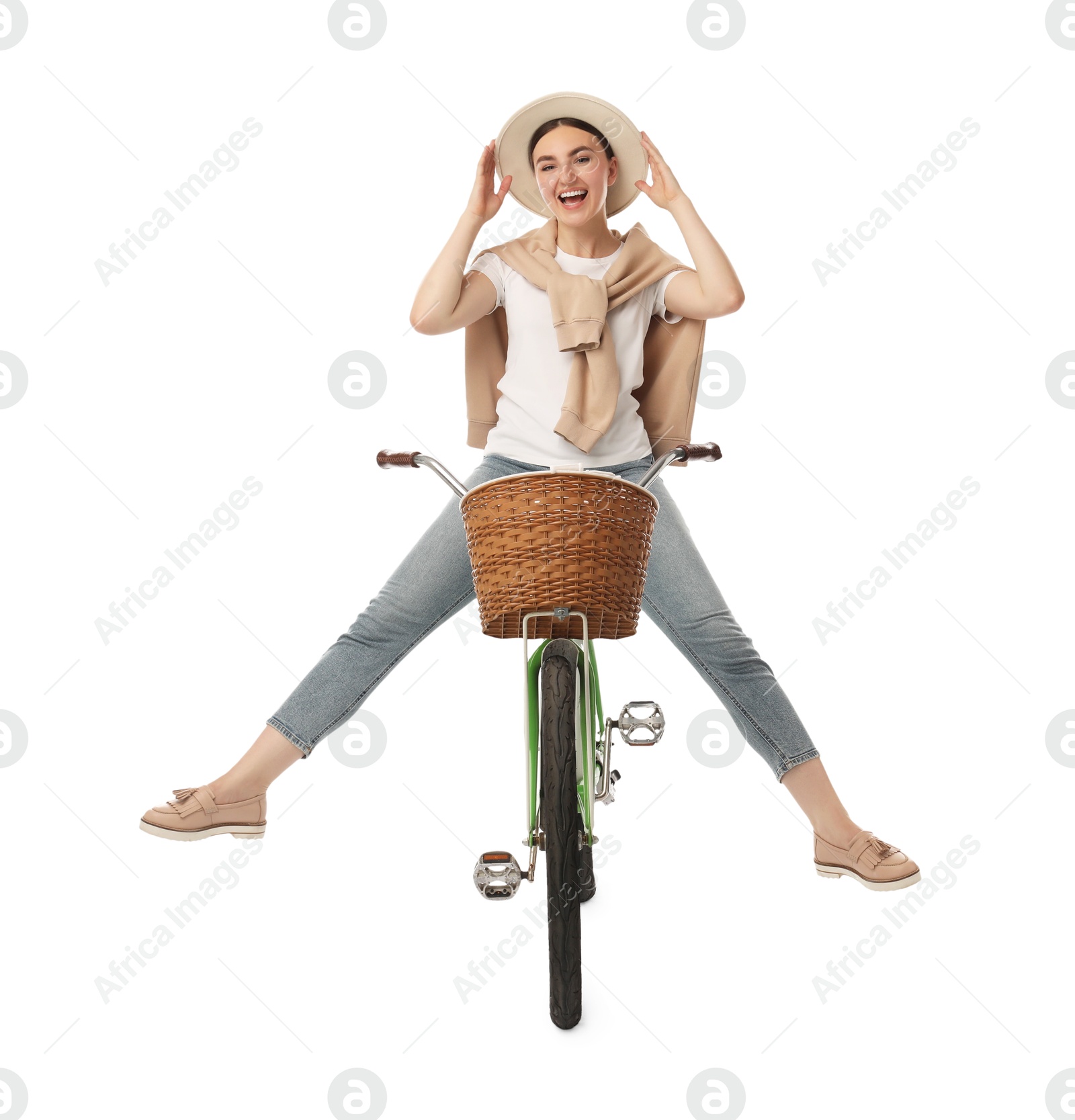 Photo of Smiling woman having fun while riding bicycle with basket on white background