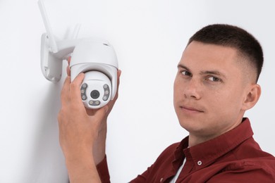 Photo of Technician installing CCTV camera on wall indoors