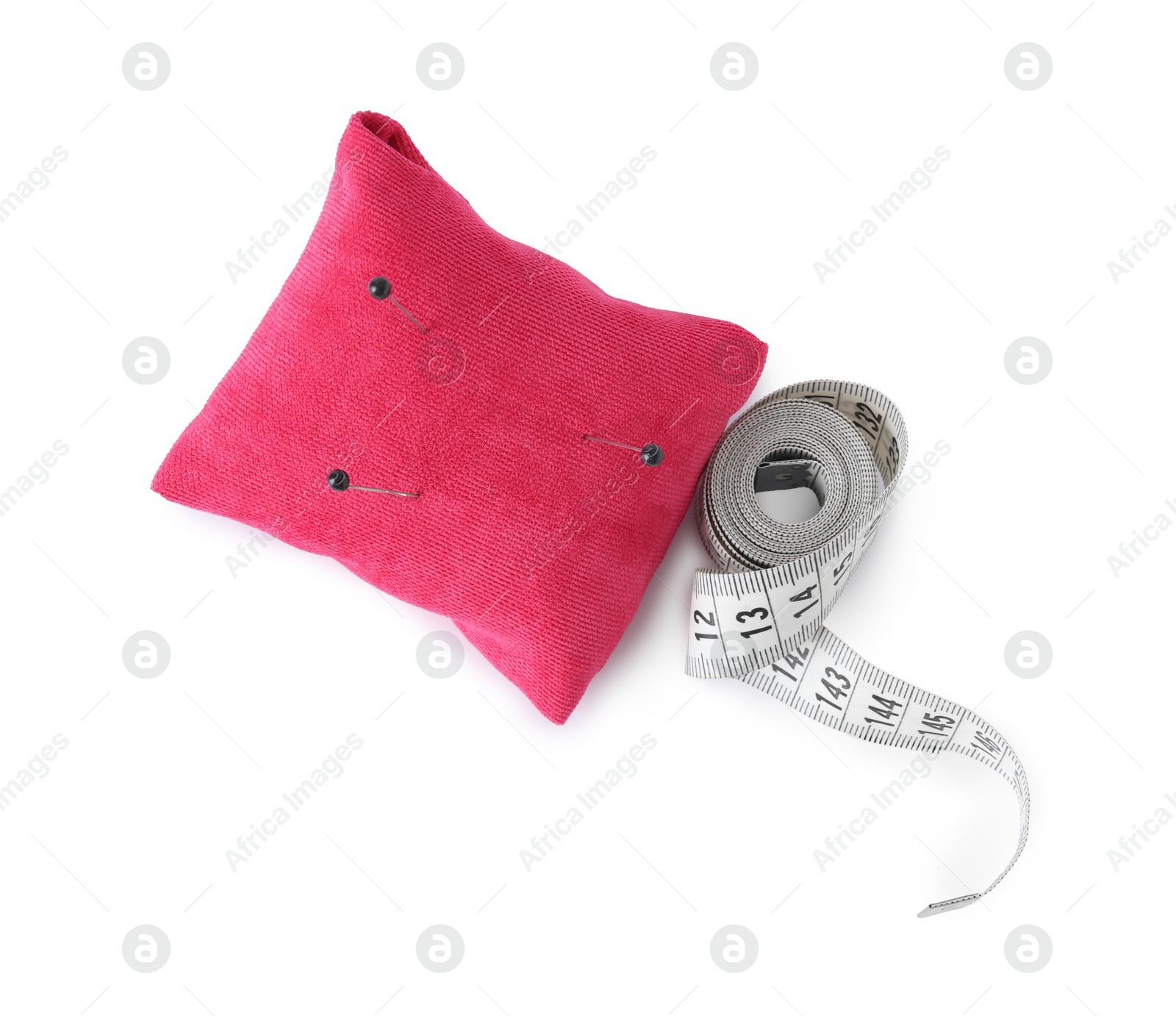 Photo of Pink pincushion with sewing pins and measuring tape isolated on white, top view
