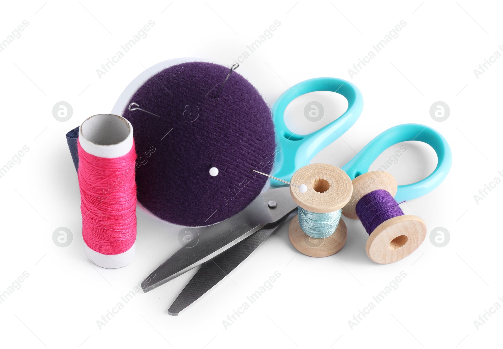 Photo of Pincushion, sewing needles, pins, spools of threads and scissors isolated on white