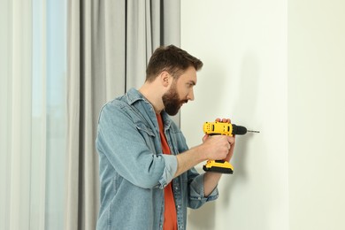 Man working with drill and wall at home