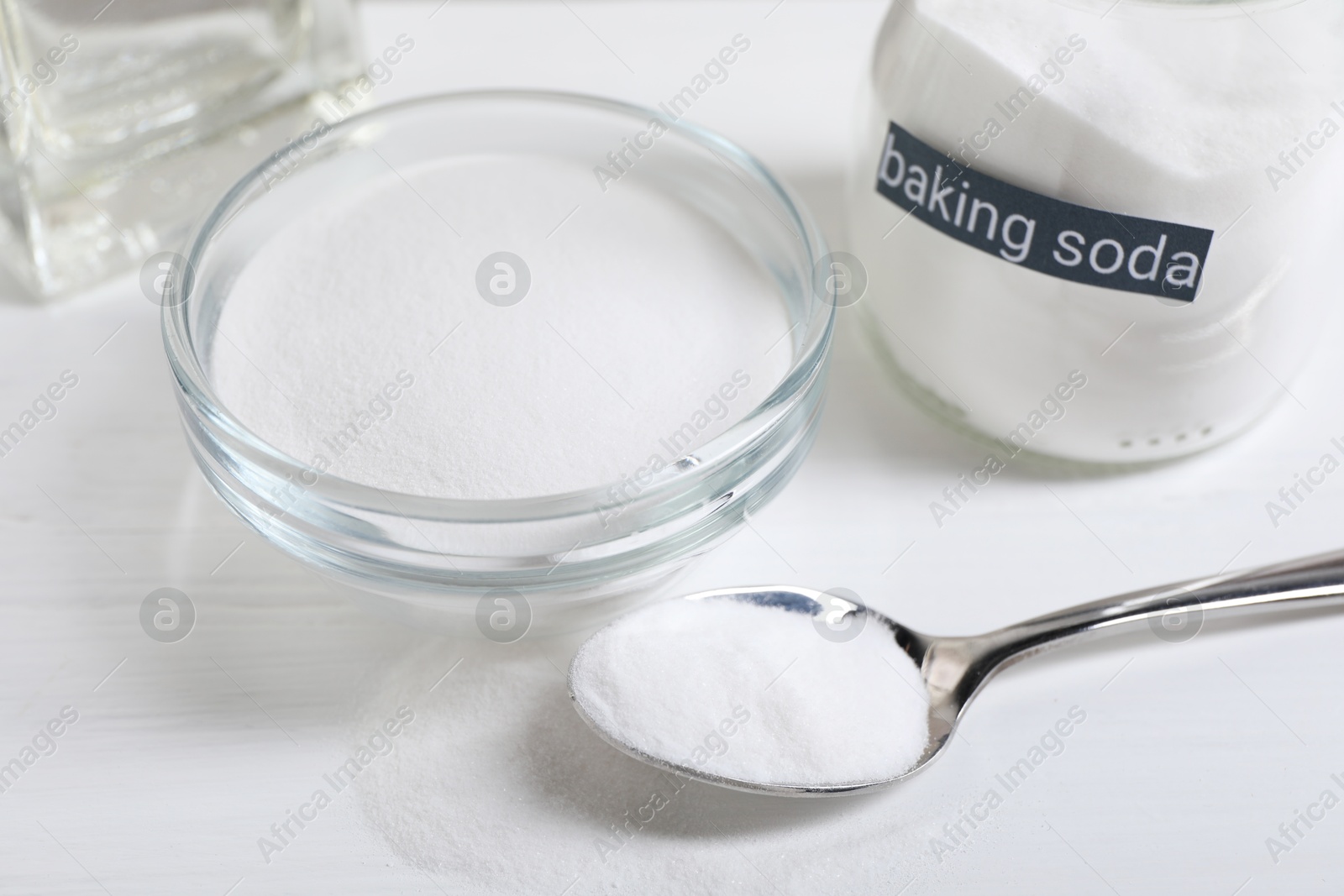 Photo of Baking soda on white wooden table, closeup