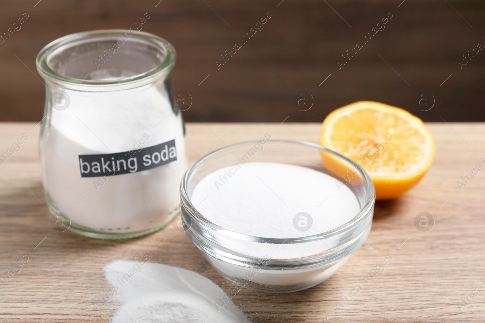 Photo of Baking soda and lemon on wooden table