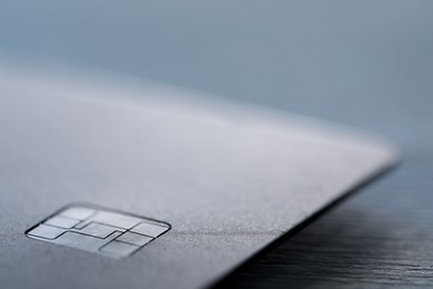 Photo of One credit card on gray background, macro view