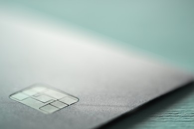 One credit card on turquoise background, macro view