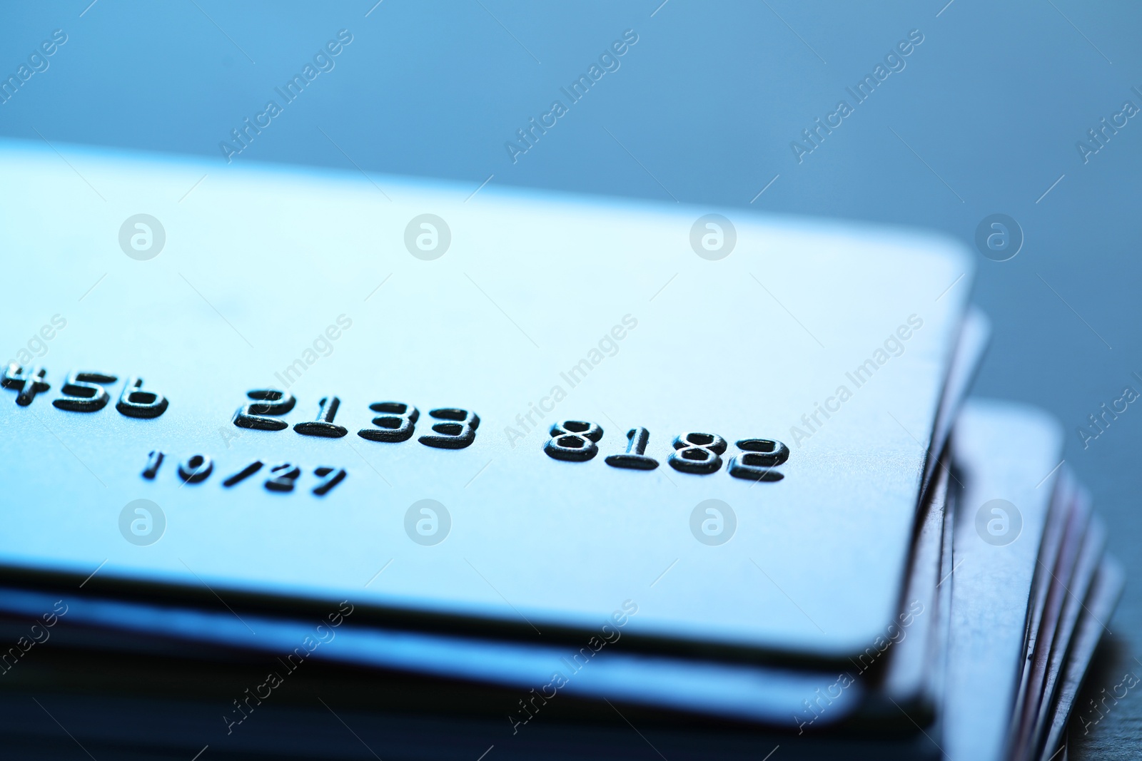 Photo of Many credit cards on blurred background, closeup view