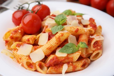 Photo of Tasty pasta with tomato sauce, cheese and basil on plate, closeup