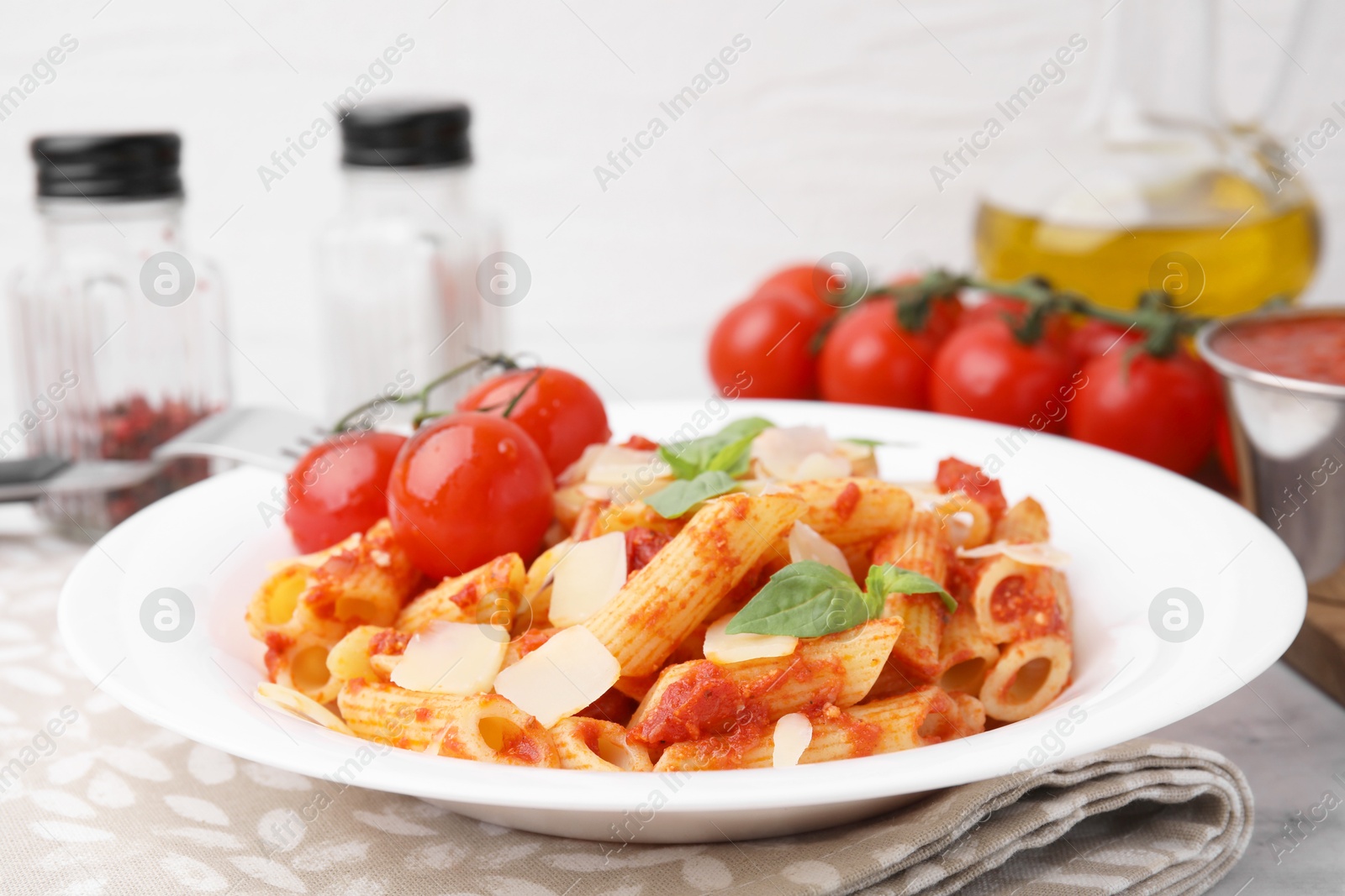 Photo of Tasty pasta with tomato sauce, cheese and basil on table