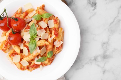 Photo of Tasty pasta with tomato sauce, cheese and basil on white marble table, top view. Space for text