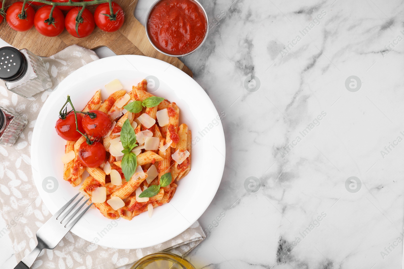 Photo of Tasty pasta with tomato sauce, cheese and basil served on white marble table, top view. Space for text