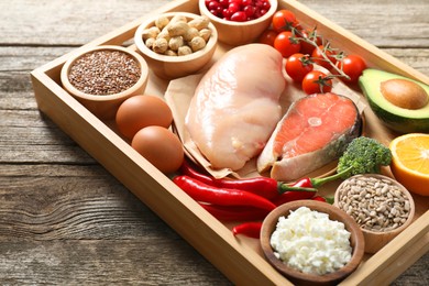 Photo of Tray with many different healthy food on wooden table, closeup