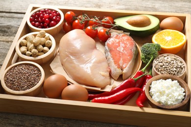 Tray with many different healthy food on wooden table, closeup