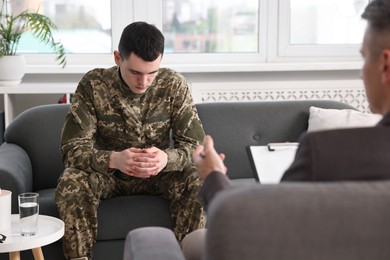 Photo of Professional psychotherapist working with military man in office