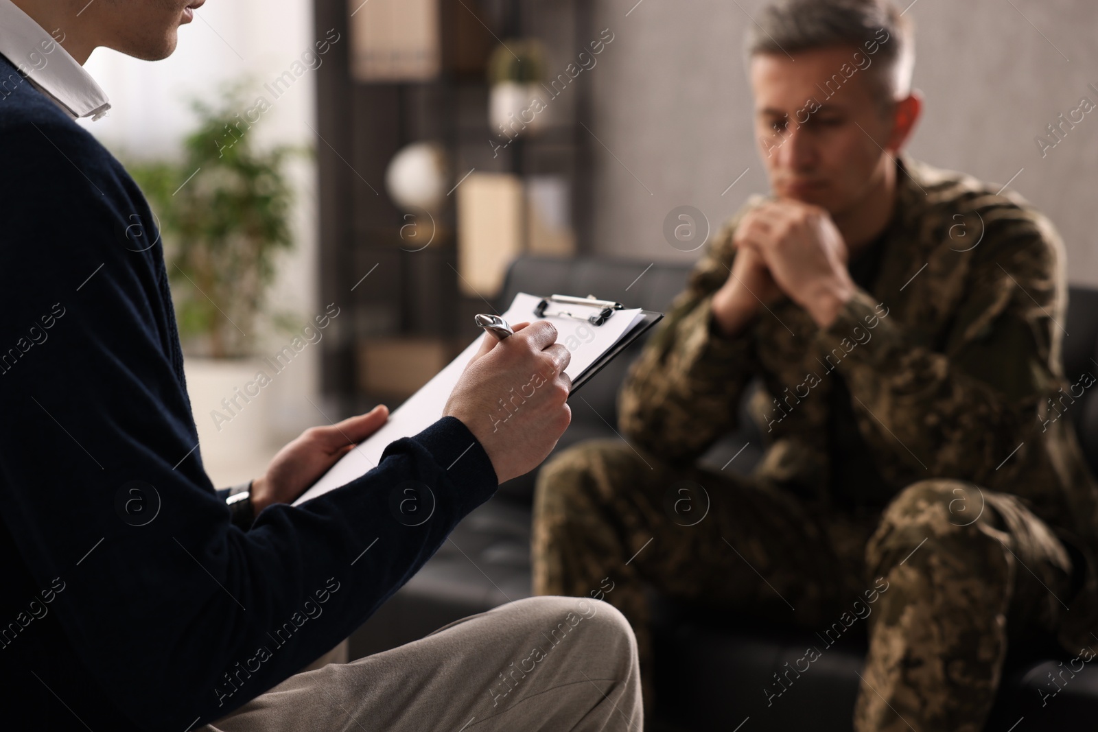 Photo of Professional psychotherapist working with military man in office, closeup