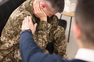 Professional psychotherapist working with military man in office