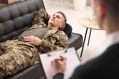 Professional psychotherapist working with military man in office