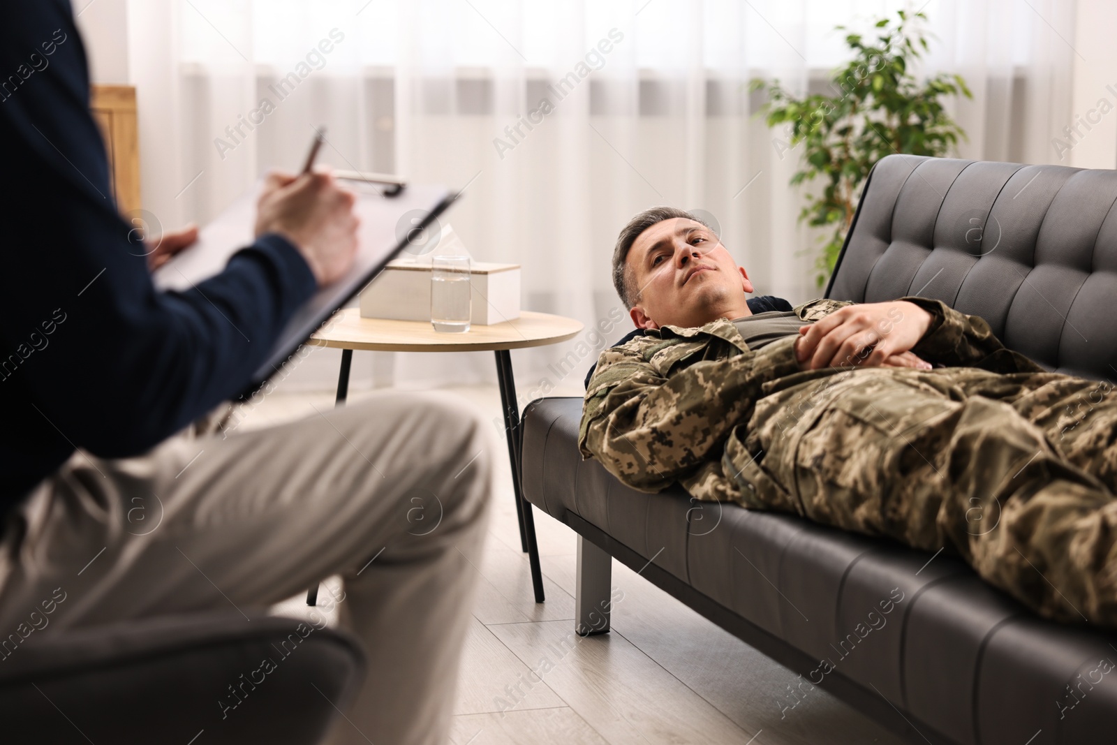 Photo of Professional psychotherapist working with military man in office