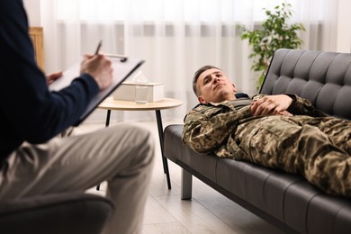 Photo of Professional psychotherapist working with military man in office