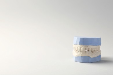 Photo of Dental model with gums on gray background, space for text. Cast of teeth