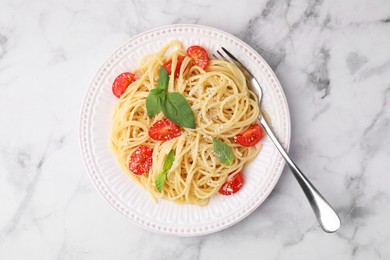 Photo of Tasty pasta with tomato, cheese and fork on white marble table, top view