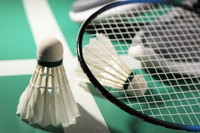 Feather badminton shuttlecocks and racket on court, closeup