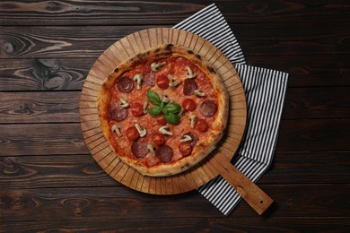 Photo of Delicious pizza with salami, tomatoes, mushrooms and basil on wooden table, top view